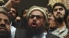 PAHafiz Saeed (center) speaks to the media outside a court in Lahore in November 2017.