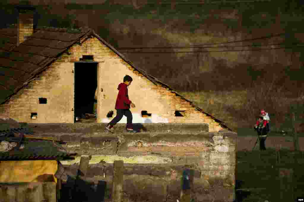 A boy walks on top of a ruined house in the Roma-populated part of Gyongyospata, some 81 kms northeast of Budapest, on March 24. (epa/Zoltan Baloght)