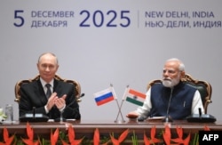 În această fotografie distribuită de agenția de stat rusă Sputnik, președintele Rusiei, Vladimir Putin, și prim-ministrul Indiei, Narendra Modi, participă la o sesiune plenară a forumului comercial India-Rusia de la New Delhi, pe 5 decembrie 2025.