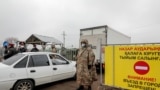 KAZAKHSTAN -- Police officers wearing a protective gear are seen at a checkpoint set up to lock down the city to prevent the spread of the COVID-19 coronavirus disease, on the outskirts of Almaty, March 23, 2020