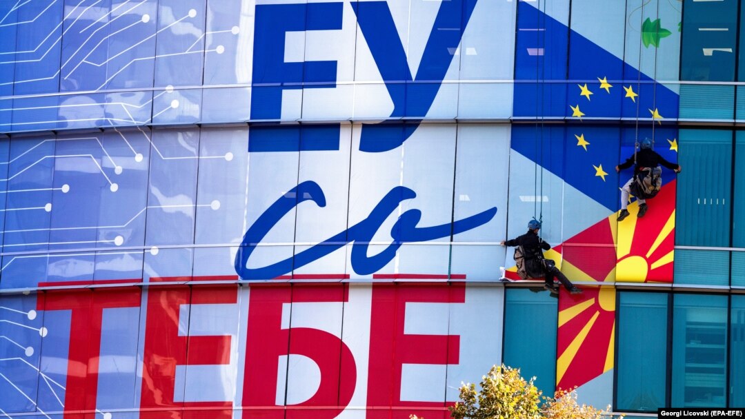 Работници поставуваат постер на седиштето на Европската Унија во Скопје 