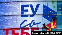 Punëtorët vendosin në zyrën e Bashkimit Evropian në Shkup posterët e rinj ku shkruan "BE-ja me ty". Shkup, 24 shtator 2021