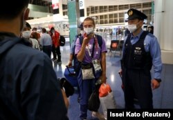 Kristina Țimanovskaia, escortată de ofițeri de polițiști japonezi pe aeroportul internațional Haneda din Tokyo, după ce a cerut ajutorul autorităților japoneze - 1 august 2021