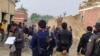 Security officials examine damage at the site of a bombing at a police station on the outskirts of Dera Ismail Khan, Pakistan, on December 12, 2023.