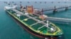 A tanker unloads imported crude oil at a terminal port in Qingdao, in China’s Shandong Province, on June 25.