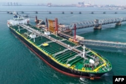 A tanker unloads imported crude oil at a terminal port in Qingdao, in China’s eastern Shandong Province in June.