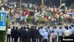 Riot police block a road during clashes with rioting Sichuan migrant workers in Xintang, near Guangzhou, on June 12.