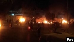 Dozens of protesters gathered outside the Iranian Consulate in Karbala on May 9, setting fire to the perimeter wall, a gate, and trailers outside.