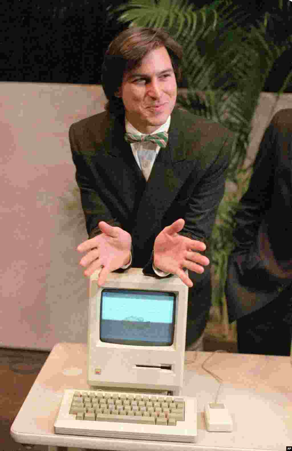 Steve Jobs, chairman of the board of Apple Computer, leaning on a new Macintosh personal computer following a shareholder&#39;s meeting January 24, 1984 in Cupertino, California. The Macintosh was initially priced at $2,495.