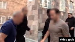 Al doilea președinte armean, Robert Kocearian (stânga), și fiul său, Sedrak Kocearian, arestați marți, 25 august. Legea armeană prevede ascunderea fețelor suspecților în asemenea situații. 