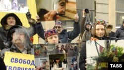 Activists hold up photographs by Umida Ahmedova outside the Uzbek Embassy in Moscow.