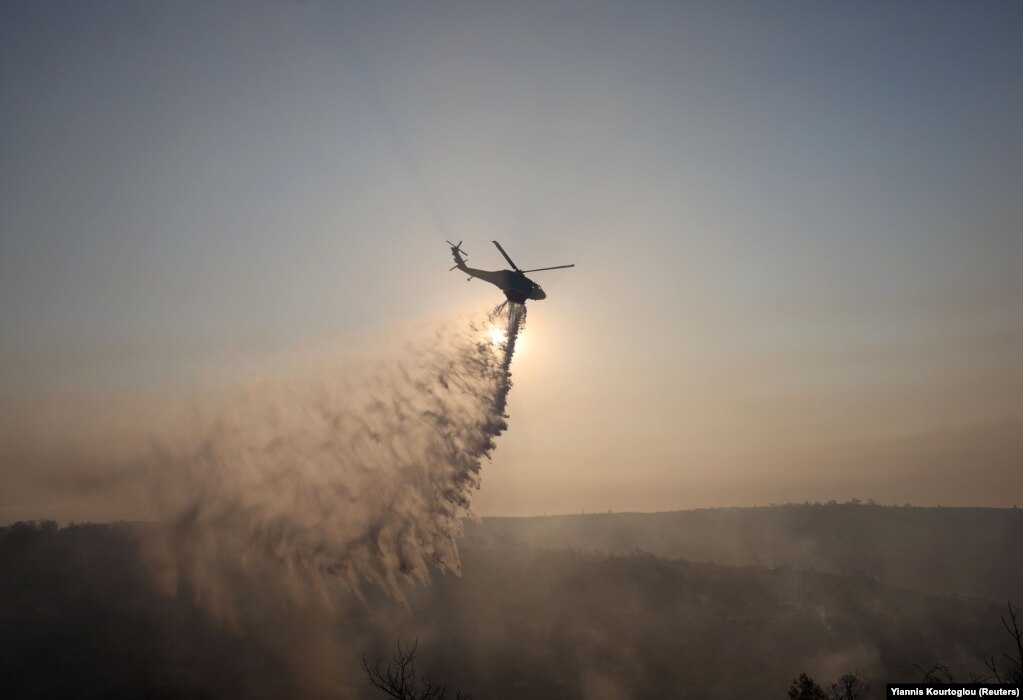 Një helikopter zjarrfikës duke hedhur ujë për të shuar një zjarr në zonën e Sunit, afër Limasolit, në Qipro, më 24 korrik.