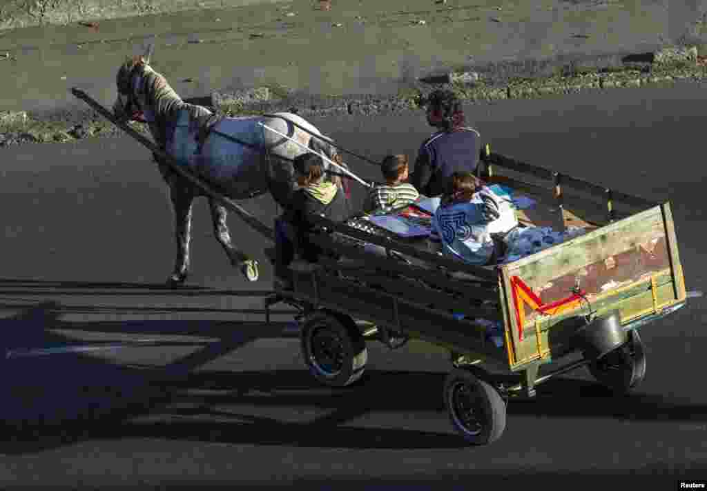 Members of a Gypsy family collect recyclables from trash containers as they make their way across the street on a horse and buggy in Belgrade, on October 20 (Reuters/Zoran Milich)