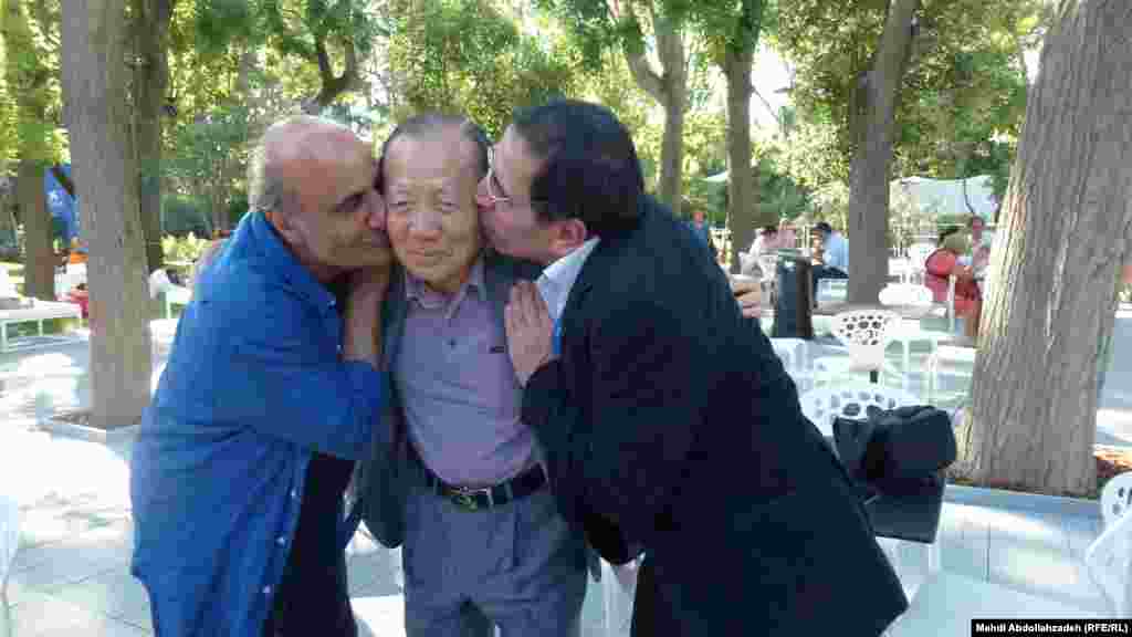 بوسه دوستانه محسن مخملباف و امیر نادری دونسل متفاوت از فیلمسازان سینمای ایران در هجرت بر صورت دونگ هو بنیانگذار و مدیر سابق جشنواره فیلم پوسان&nbsp;