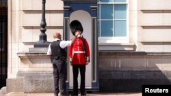 Vízzel itatják a brit királynő őrségének egyik tagját a londoni hőségben, 2022. július 18-án. A következő nap volt a brit történelem legforróbb napja, ami jelentős fennakadásokhoz és lakástüzekhez vezetett