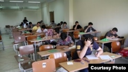 Students in an Iranian school are taking the final exam at third grade of high school. Undated.