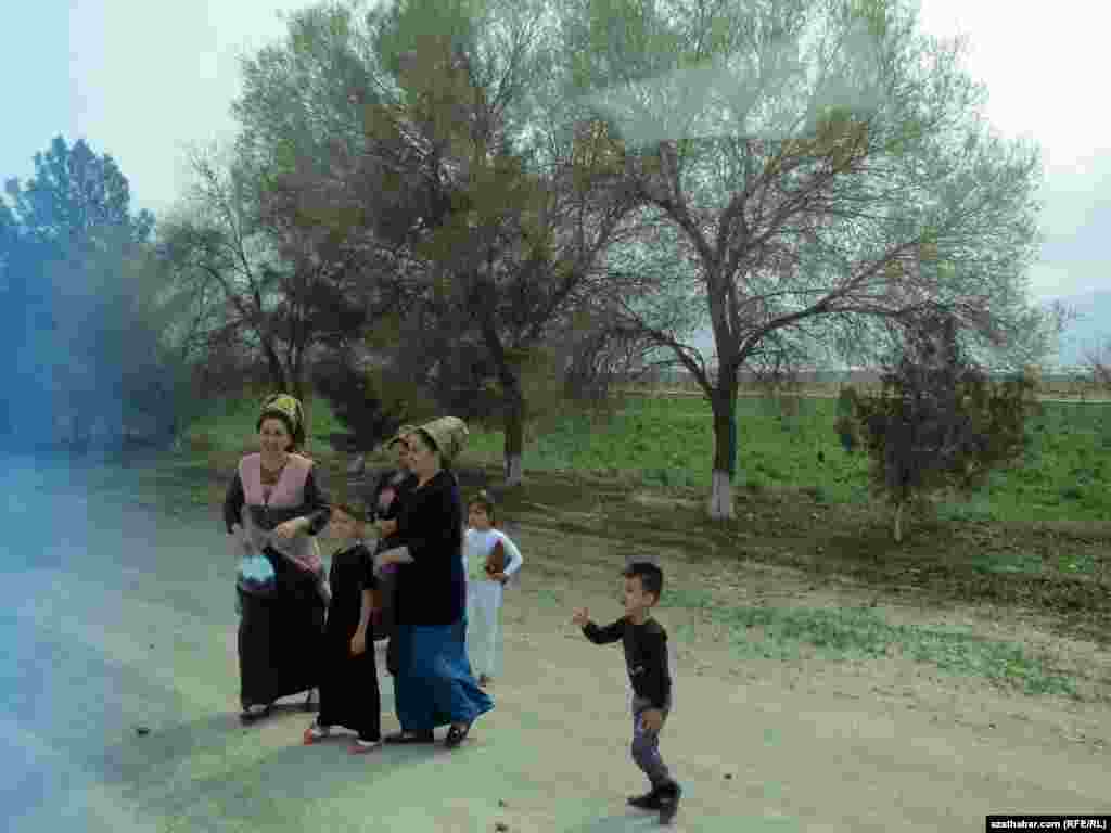 Adamlar ýoluň gyrasynda awtobusa garaşýarlar.