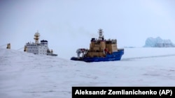 An Icebreaker cuts a path for a cargo ship near a port on Alexandra Land Island near Nagurskoye, Russia's northernmost military outpost.