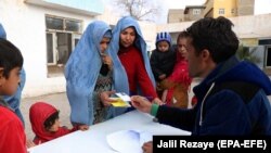 ارشیف، هرات کې یو بشردوستانه فعال یوې افغانې کورنۍ ته د بشري مرستو د ورکولو لپاره د نوم لیکنې پر مهال
