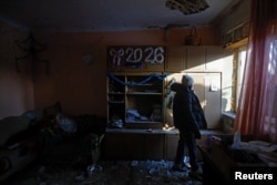 Аліна стоїть у своєму домі, пошкодженому внаслідок, як заявила російська влада, удару українського безпілотника в Донецьку, місті України, що контролюється Росією. 17 січня 2026 року. Фото REUTERS