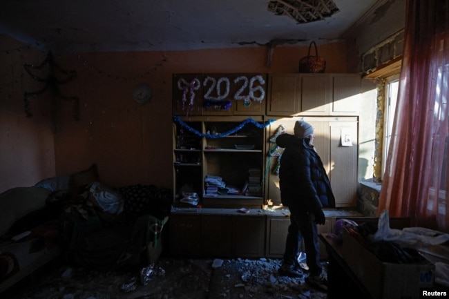 Алина стоит в своем доме, который был поврежден в результате, как заявили российские власти, удара украинского беспилотника в Донецке, городе Украины, контролируемом Россией. 17 января 2026 года. Фото REUTERS