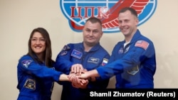 U.S. astronauts Christina Koch and Nick Hague and Russia's Aleksei Ovchinin (center) pose before their launch.