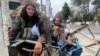Taliban fighters sit at a checkpoint in Kabul.
