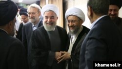 President Hassan Rouhani shaking hands with Amoli Larijani, with Ali Larijani on the left. Undated. File photo