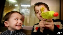 Чеченские мальчики играют с водяным пистолетиком. Польша, январь, 2008 г.