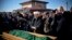 Members of the Crimean Tatar community pray over the coffin of Reshat Ametov during his funeral in Simferopol on March 18. His body bore the marks of a violent death, according to Human Rights Watch.