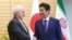 Iranian Foreign Minister Mohammad Javad Zarif (L) and Japanese Prime Minister Shinzo Abe shake hands at Abe's official residence in Tokyo on May 16, 2019. 
