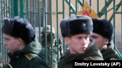 A Russian soldier guards the entrance to St. Petersburg's Mozhaisky Academy while students evacuate following a blast at the facility on April 2. 