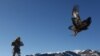 A hunter holds his tamed golden eagle during a traditional hunting contest outside the village of Kaynar in Almaty region, Kazakhstan December 8, 2019. REUTERS/Pavel Mikheyev