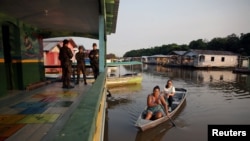 Văslind spre vot. Două femei sosesc la o secție de votare din Iranduba, în Amazonia braziliană, în dimineața zilei de 4 octombrie. 