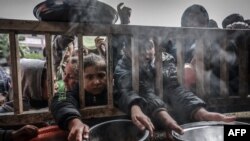Газа тилкесинин түштүгүндөгү Рафах шаарындагы мамлекеттик мектепте тамак-аш алуу үчүн чогулган палестиналык балдар. 19-февраль, 2024-жыл. 