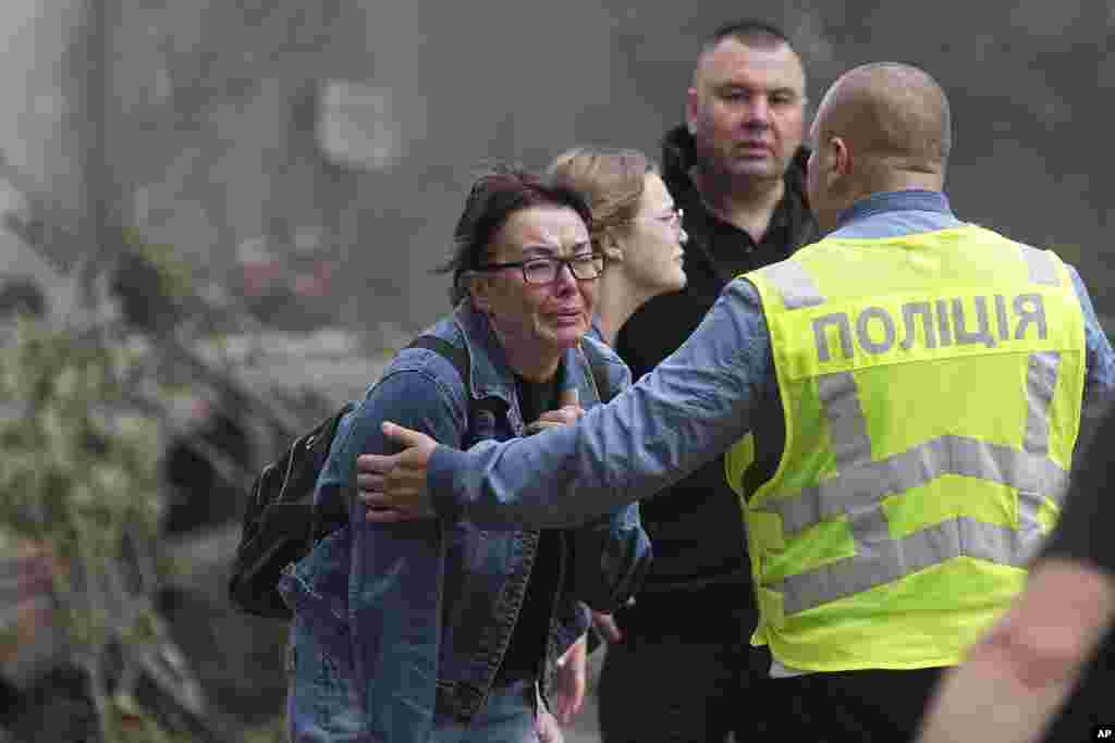 Ukrainian women react outside a destroyed apartment building after a Russian missile attack on Kyiv.