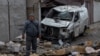 A man stands among debris next to a destroyed car following a drone attack on Odesa on November 10.