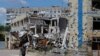 A man walks past a destroyed building in Mariupol