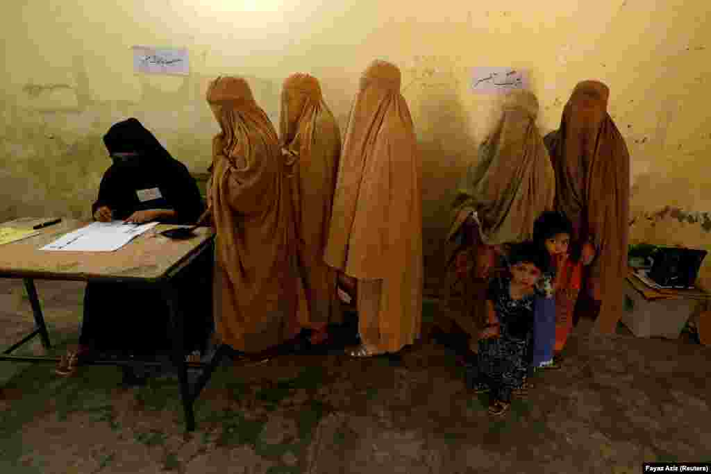 Women, clad in burqas, stand in line to cast their ballots at a polling station during Pakistan&#39;s national elections in Peshawar on July 25. (Reuters/Fayaz Aziz)