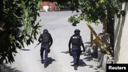 Президенттин резиденциясынын айлана-тегерегинде жүргөн полиция кызматкерлери, Порт-о-Пренс, Гаити, 7-июль 2021-жыл. 