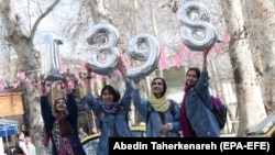 Iranian women hold numbers forming the Persian New Year 1398, Norooz, on New Year eve in Tehran, March 20, 2019