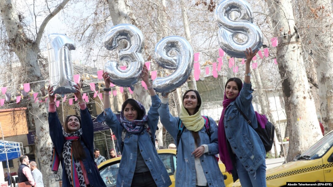 Iranian girls hold up numbers forming the Persian new year 1398 ahead of Norouz in Tehran on March 20.