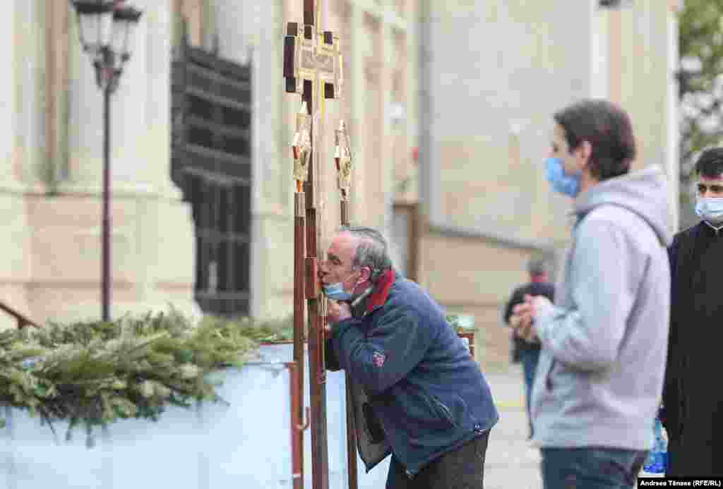 Un bărbat sărută o cruce &#238;n timpul slujbei religioase oficiată &#238;n Joia Mare, la Palatul Patriarhiei din București, Rom&#226;nia. 