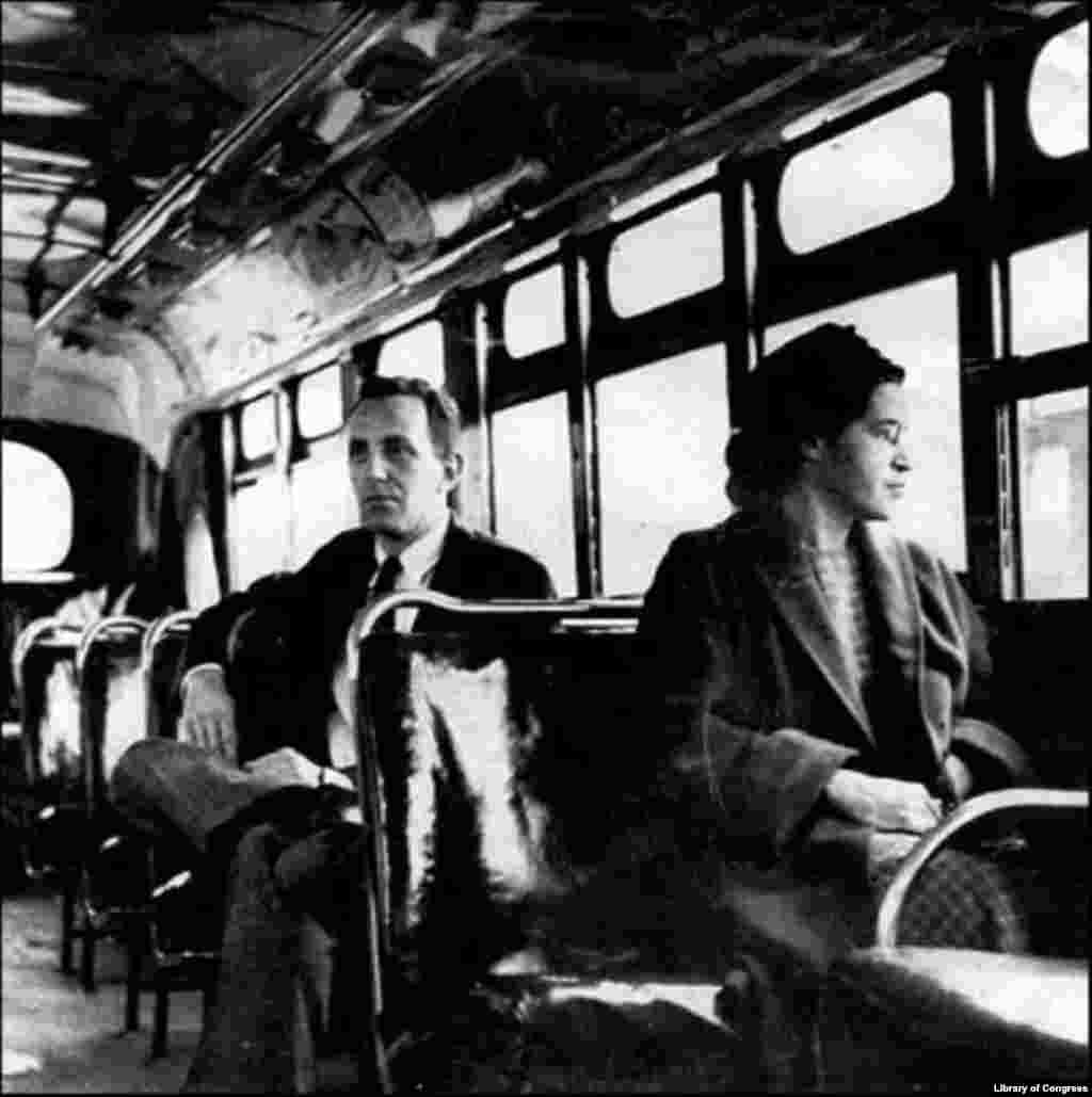 Rosa Parks sits with a journalist in the front of a bus in Montgomery, Alabama, in 1956, after the U.S. Supreme Court ruled segregation illegal on the city&#39;s transport system. The court case was the result of the bus boycott initiated by Parks and fellow activists. 