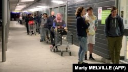 2020-nji ýylyň 11-nji awgustynda alyjylar Wellington şäheriniň etegindäki supermarkete girmäge garaşýarlar.