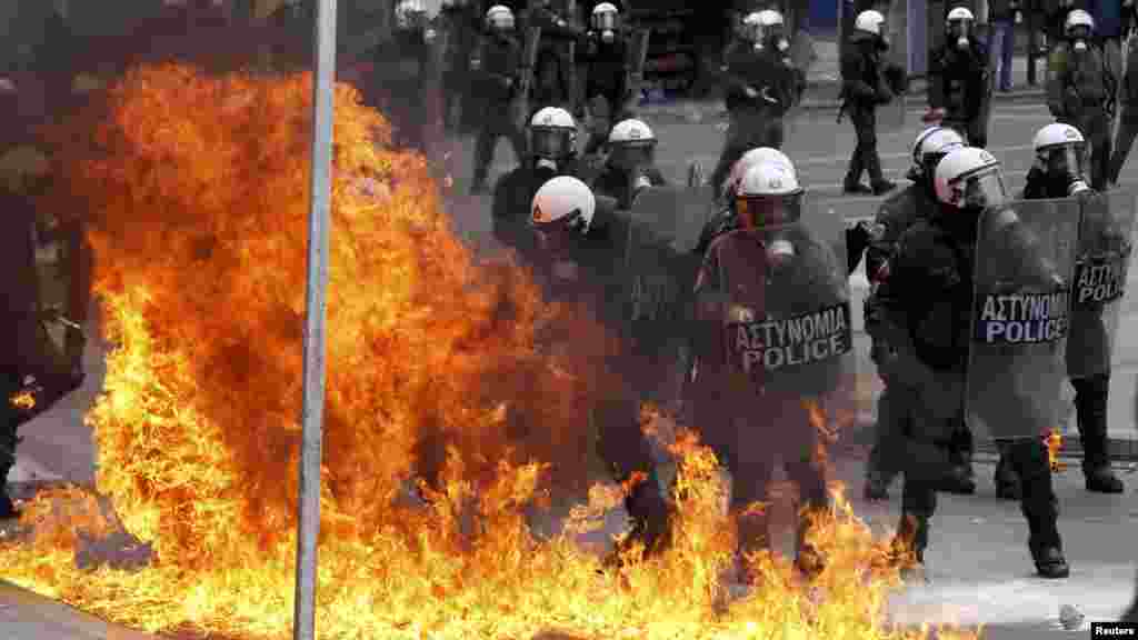 A petrol bomb explodes near Greek riot police during protests against planned austerity reforms in Athens on February 10. (REUTERS/Yiorgos Karahalis)