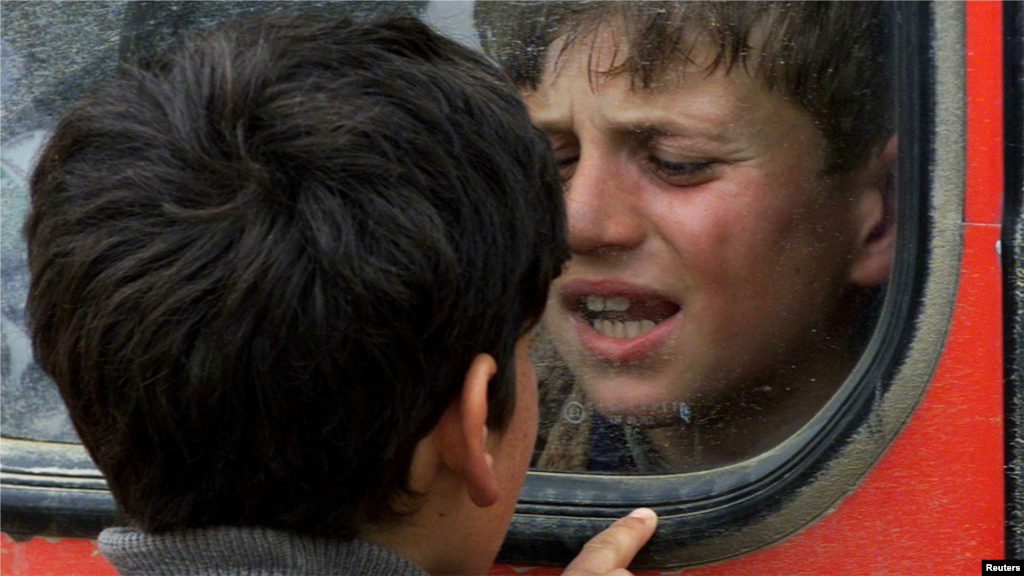 Kosovo: Dva albanska dječaka pokušavaju komunicirati kroz prozor autobusa u izbjegličkom kampu u Stankovcu, 21. aprils 1999. Prema podacima UN-a, više od 200.000 kosovskih Albanaca bili su izbjeglice u Sjevernoj Makedoniji.Ukrajina: Dvanaestogodišnja Aleksandra drži svoju šestogodišnju sestru Esjeju, koja je plakala dok je mahala njihovoj majci Irini, nakon što su se ukrcale u autobus kako bi pobjegle od ruske invazije.