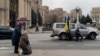 People kneel to honor a fallen Ukrainian soldier during a funeral procession on Independence Square on Kyiv on January 3. 