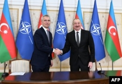 NATO Secretary-General Jens Stoltenberg (left) and Ilham Aliyev deliver press statements following talks in Baku on March 17.