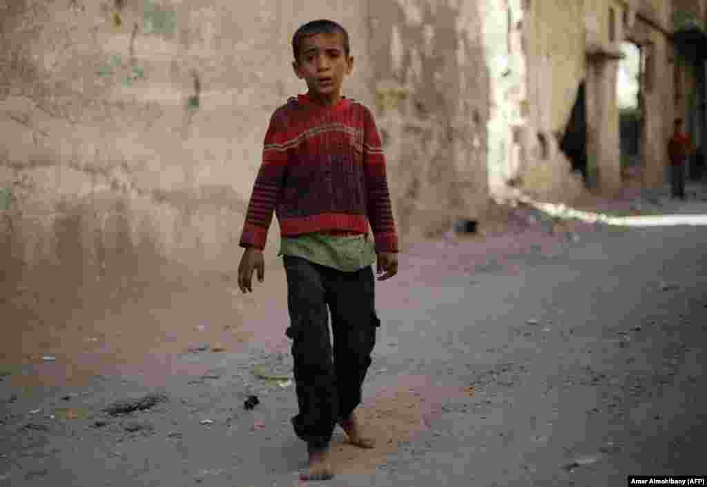 A Syrian boy cries outside a makeshift morgue following reported shelling by Syrian government forces in the rebel-held town of Douma on the outskirts of Damascus on October 26. (AFP/Amer Almohibany)